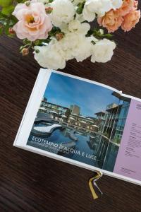 a magazine sitting on top of a table with flowers at Aqualux Hotel Spa & Suite in Bardolino