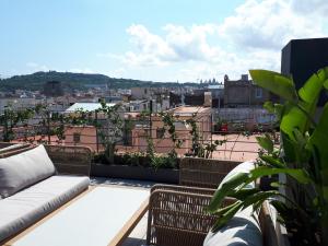 a balcony with a couch and a view of a city at Silken Ramblas in Barcelona