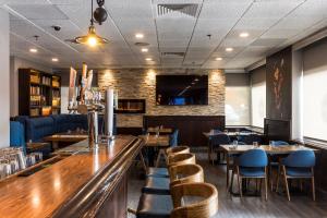 a restaurant with tables and chairs and a bar at Ottawa Embassy Hotel & Suites in Ottawa