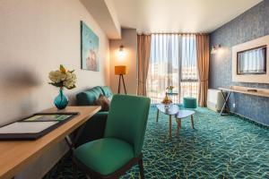 a hotel room with a desk and a room at Marina Burgas Hotel in Burgas City