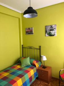 a bedroom with green walls and a bed and a lamp at Apartamentos Puerta del Sol in Castellón de la Plana
