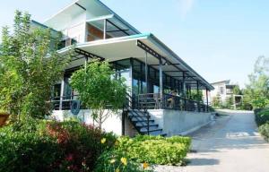 a building with glass doors and stairs in a yard at Khao Kho Overview Resort in Khao Kho