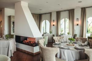 een eetkamer met een tafel en een open haard bij B Bou Hotel Cortijo Bravo in Vélez-Málaga