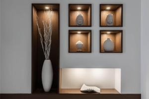 a wall with four framed pictures and a vase at Sea Elegance in Oliveri