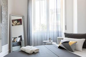 a bedroom with a bed and a mirror and a window at Sea Elegance in Oliveri