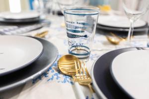 a table with plates and a fork and a glass at Sea Elegance in Oliveri
