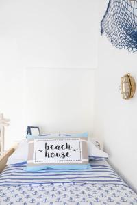 a bedroom with a bed with a beach house sign on it at Sea Elegance in Oliveri