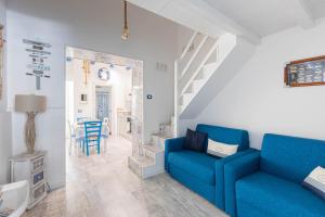 a living room with a blue couch and stairs at Sea Elegance in Oliveri
