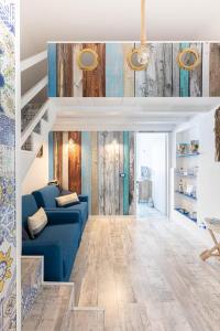 a living room with a blue couch and a staircase at Sea Elegance in Oliveri