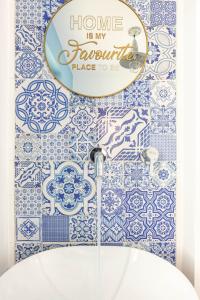 a bathroom with blue and white tiles and a mirror at Sea Elegance in Oliveri