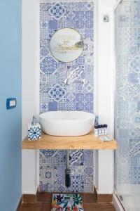 a bathroom with a sink and blue and white tiles at Sea Elegance in Oliveri