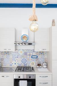 a kitchen with white cabinets and a stove top oven at Sea Elegance in Oliveri