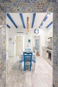 a blue and white kitchen with a table and chairs at Sea Elegance in Oliveri