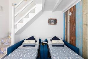 two beds in a room with a staircase at Sea Elegance in Oliveri