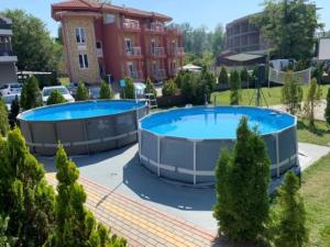 two large swimming pools in front of a building at Sobe Srebrno Jezero in Veliko Gradište