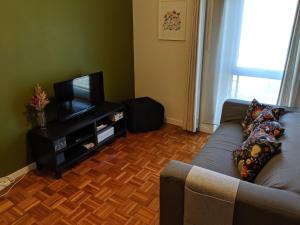a living room with a couch and a television at Apartamento em Monsanto - Porto in Porto