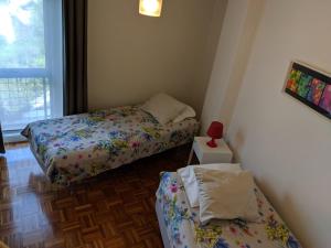 a small room with two beds and a window at Apartamento em Monsanto - Porto in Porto