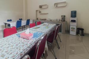 a room with a table and chairs and a kitchen at Clean & Comfort Homestay in Ambon