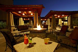 a patio with two tables with drinks and a fire pit at Wyndham El Paso Airport and Water Park in El Paso