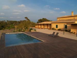 uma casa com piscina em frente a uma casa em Agroturismo Ses Arenes em Colonia Sant Jordi