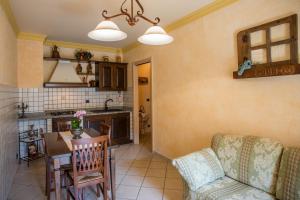 a kitchen and a living room with a table and a couch at La cor dé Jérémie in Montjovet