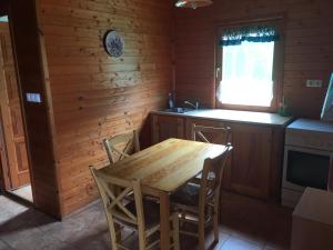 a kitchen with a wooden table and chairs in a cabin at Aquatherma Termálfalu és Kemping in Zalaegerszeg