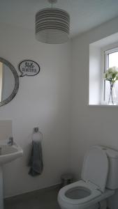 a white bathroom with a toilet and a sink at Belmullet Townhouse in Belmullet