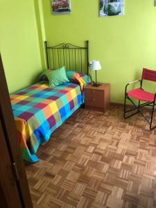 a bedroom with a bed and a chair at Apartamentos Puerta del Sol in Castellón de la Plana