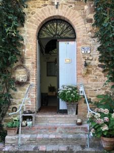 una entrada a un edificio de piedra con una puerta azul en B&B Agriturismo Casa Vallona, en Monte San Pietro