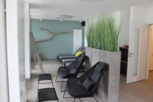 uma sala de espera com cadeiras pretas e uma planta em Appartement Seaside em Pelzerhaken