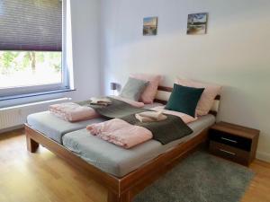 Una cama con almohadas rosas y verdes. en Apartments am Wall, en Bremen