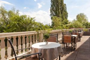 une rangée de tables et de chaises sur un balcon dans l'établissement Hôtel Restaurant Verger des Châteaux, The Originals Relais, proche Sélestat, à Dieffenthal