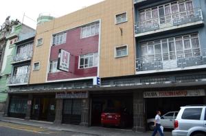 a man walking in front of a building at Hotel Del Centro in Puebla
