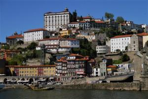 eine Gruppe von Gebäuden auf einem Hügel neben dem Wasser in der Unterkunft Chez Moi Bolhão in Porto