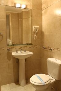 a bathroom with a sink and a toilet and a mirror at Apolo Atlantis in Mar del Plata