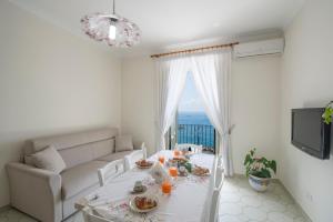 een witte woonkamer met een tafel en een bank bij Amalfi Moon in Amalfi