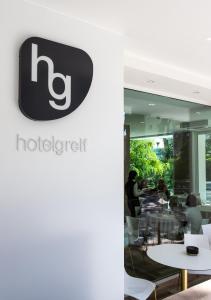 a sign for the h hotel on the wall of a restaurant at Hotel Greif in Lido di Jesolo