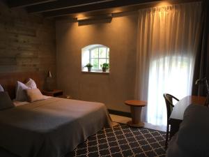 um quarto de hotel com uma cama e uma janela em B&B bij Bedaf em Uden
