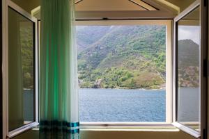ventana en una habitación con vistas al lago en Apartmani Vesna, en Tivat