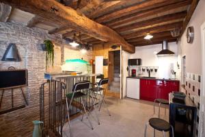 a kitchen with red cabinets and a bar with stools at La Petite Sentence de Noyers in Noyers