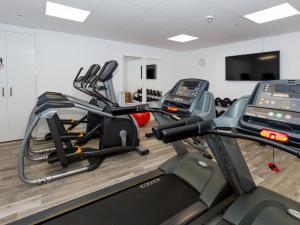 een fitnessruimte met twee loopbanden en twee crosstrainers bij DORMERO Hotel Salzgitter in Salzgitter