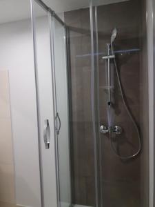 um chuveiro com uma porta de vidro na casa de banho em Liberty Hostel Lisbon em Lisboa
