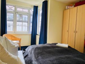 1 dormitorio con cortinas azules, 1 cama y ventana en Villa Sanddorn, en Binz