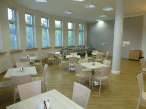 un comedor con mesas, sillas y ventanas en Hotel Giżycko, en Giżycko