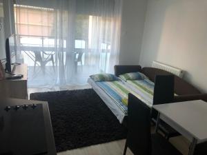 a room with a bed and a window with a table at Belle Casa 24 in Debrecen