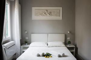 Un dormitorio con una cama con toallas y flores. en Michelangelo's Place, en Florencia