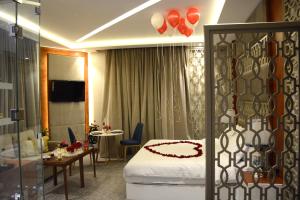 Habitación de hotel con cama, mesa y sillas en E1 Hotel en Al Kharj