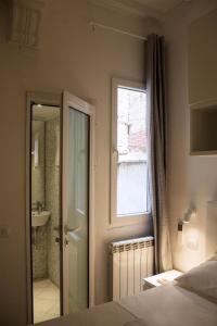 1 dormitorio con cama, ventana y baño en Michelangelo's Place, en Florencia