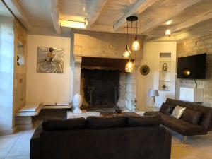 ein Wohnzimmer mit einem Sofa und einem Kamin in der Unterkunft Villa Donna jacuzzi jardin billard centre la Brèche in Niort