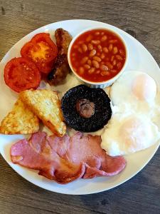 a plate of breakfast food with eggs bacon beans and toast at The Vine B & B in South Thoresby